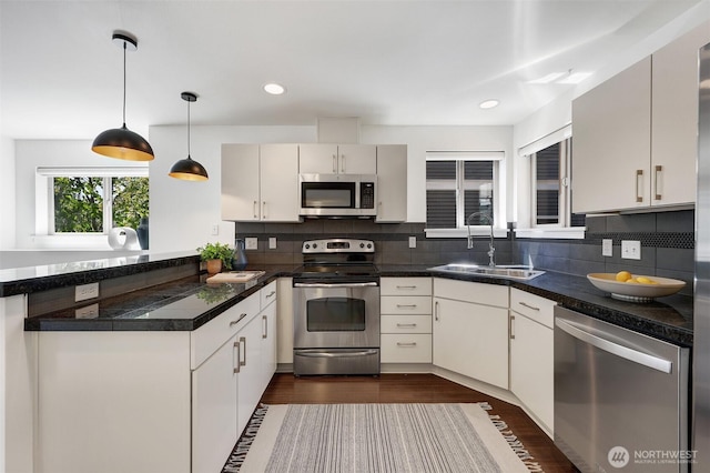 228 24th Ave E Unit A, Seattle, WA 98112 - kitchen featuring appliances with stainless steel finishes, a peninsula, tasteful backsplash, dark wood-style floors, and recessed lighting