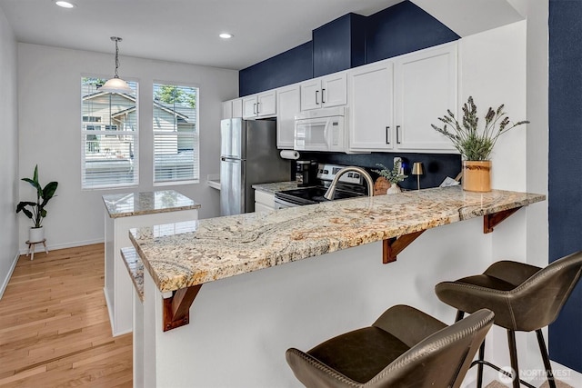 15325 SE 155th Pl Unit Q2, Renton, WA 98058 - kitchen with stainless steel appliances, light wood finished floors, recessed lighting, white cabinetry, and a peninsula