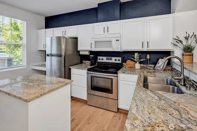 15325 SE 155th Pl Unit Q2, Renton, WA 98058 - kitchen featuring appliances with stainless steel finishes, light wood-style floors, white cabinetry, and a center island
