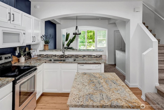15325 SE 155th Pl Unit Q2, Renton, WA 98058 - kitchen with white appliances, light stone countertops, white cabinetry, and a peninsula