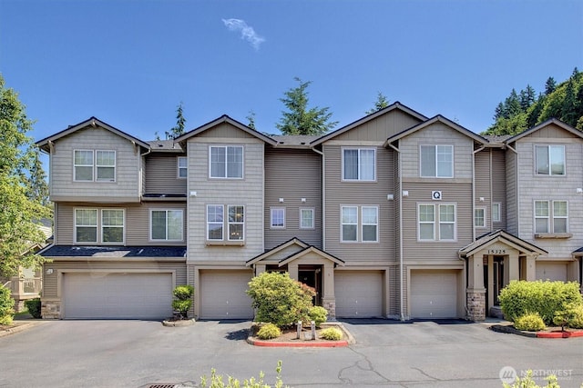 15325 SE 155th Pl Unit Q2, Renton, WA 98058 - townhome / multi-family property featuring a garage, stone siding, and driveway