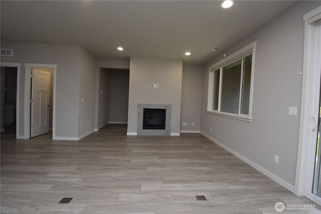 4650 Viridian Ave SW, Port Orchard, WA 98367 - unfurnished living room with recessed lighting, a glass covered fireplace, and light wood-type flooring