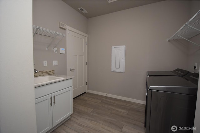 4650 Viridian Ave SW, Port Orchard, WA 98367 - laundry room featuring electric panel, washing machine and clothes dryer, light wood-style floors, and cabinet space