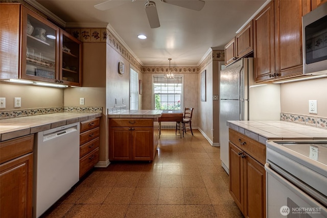 601 Yakima St, Wenatchee, WA 98801 - kitchen featuring white appliances, tile countertops, a ceiling fan, brown cabinetry, and crown molding