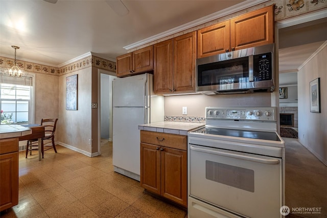 601 Yakima St, Wenatchee, WA 98801 - kitchen featuring white appliances, tile countertops, brown cabinetry, a chandelier, and crown molding