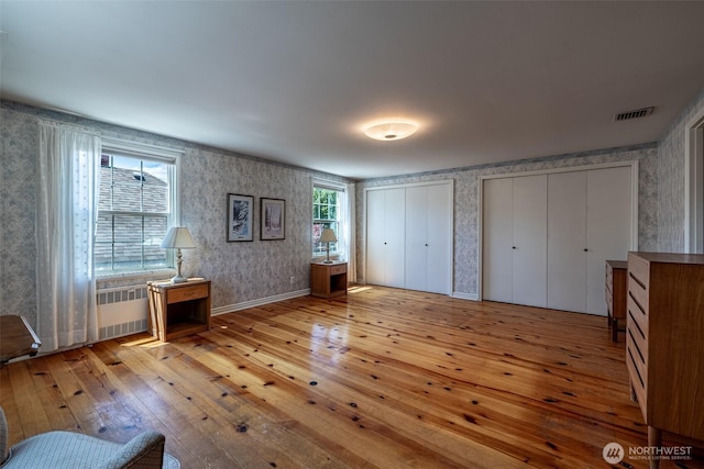 601 Yakima St, Wenatchee, WA 98801 - unfurnished bedroom with wallpapered walls, light wood-style flooring, and multiple closets