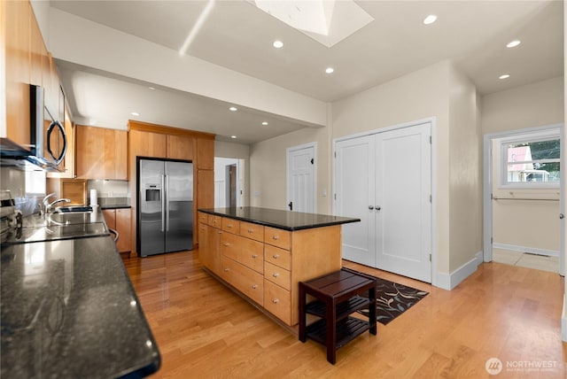 216 4th St E, Tonasket, WA 98855 - kitchen featuring stainless steel appliances, a skylight, a center island, light wood-style flooring, and recessed lighting
