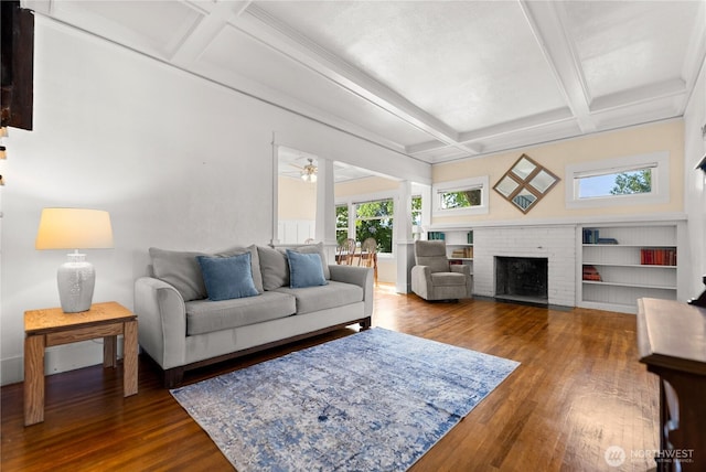 216 4th St E, Tonasket, WA 98855 - living room featuring coffered ceiling, wood finished floors, beamed ceiling, a brick fireplace, and ceiling fan