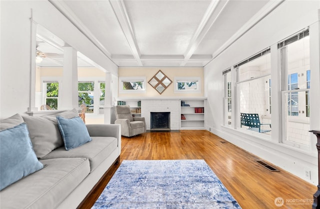 216 4th St E, Tonasket, WA 98855 - living room featuring wood finished floors, beam ceiling, a brick fireplace, ceiling fan, and coffered ceiling