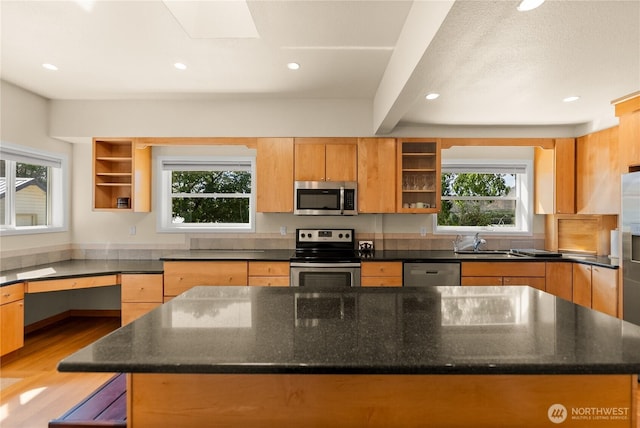 216 4th St E, Tonasket, WA 98855 - kitchen with stainless steel appliances, a kitchen island, dark stone counters, recessed lighting, and light wood-type flooring