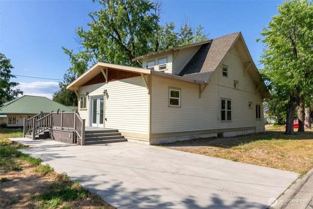 216 4th St E, Tonasket, WA 98855 - view of side of property with french doors, a wooden deck, and roof with shingles