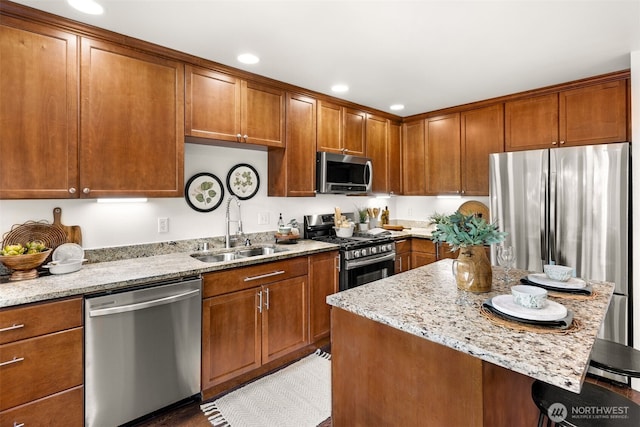 5955 Delridge Way SW, Seattle, WA 98106 - kitchen with stainless steel appliances, light stone countertops, a kitchen bar, brown cabinets, and recessed lighting
