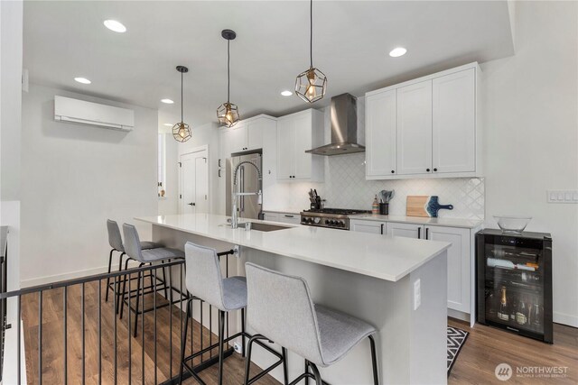 3418 23rd Ave W, Seattle, WA 98199 - kitchen featuring wall chimney exhaust hood, beverage cooler, a wall unit AC, dark wood-style floors, and stainless steel refrigerator