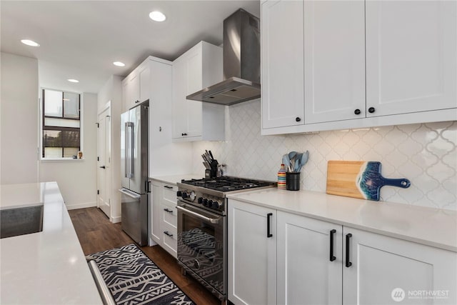 3418 23rd Ave W, Seattle, WA 98199 - kitchen with wall chimney range hood, high quality appliances, dark wood-style floors, white cabinets, and recessed lighting