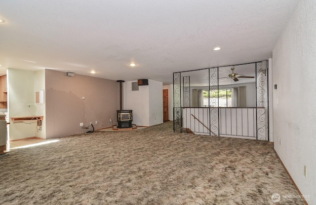 1203 Contra Costa Ave, Fircrest, WA 98466 - carpeted empty room featuring a wood stove, a ceiling fan, recessed lighting, and a textured ceiling