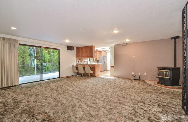 1203 Contra Costa Ave, Fircrest, WA 98466 - unfurnished living room with a wood stove, recessed lighting, and carpet flooring
