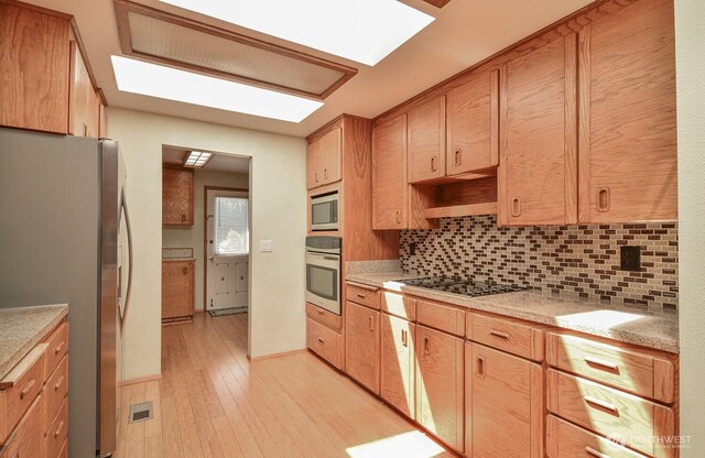 1203 Contra Costa Ave, Fircrest, WA 98466 - kitchen with appliances with stainless steel finishes, backsplash, light countertops, and light wood-style flooring