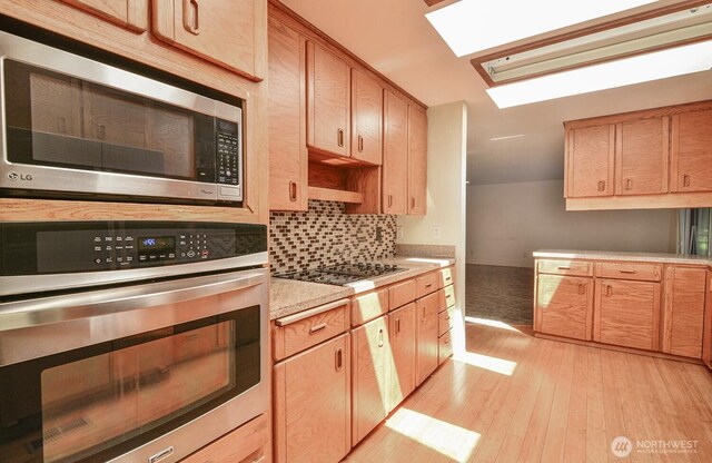 1203 Contra Costa Ave, Fircrest, WA 98466 - kitchen featuring appliances with stainless steel finishes, light countertops, light wood finished floors, backsplash, and light brown cabinetry
