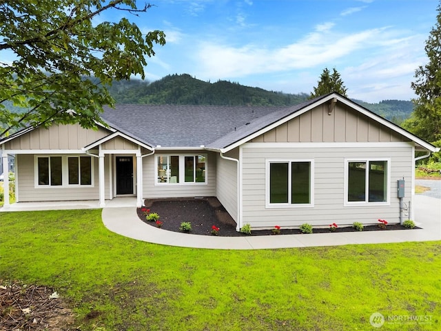 281 Shallow Shore Rd, Bellingham, WA 98229 - view of front of house featuring board and batten siding, a front lawn, and roof with shingles