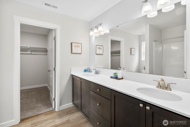 281 Shallow Shore Rd, Bellingham, WA 98229 - full bathroom featuring a walk in closet, double vanity, and wood finished floors