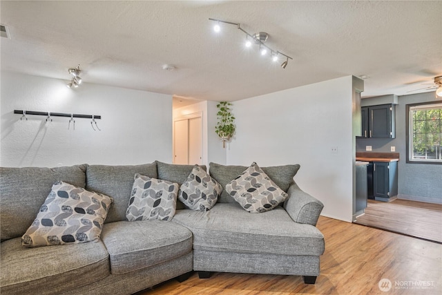 642 SW 5th Ave, Castle Rock, WA 98611 - living room featuring light wood finished floors, a textured ceiling, track lighting, and a ceiling fan