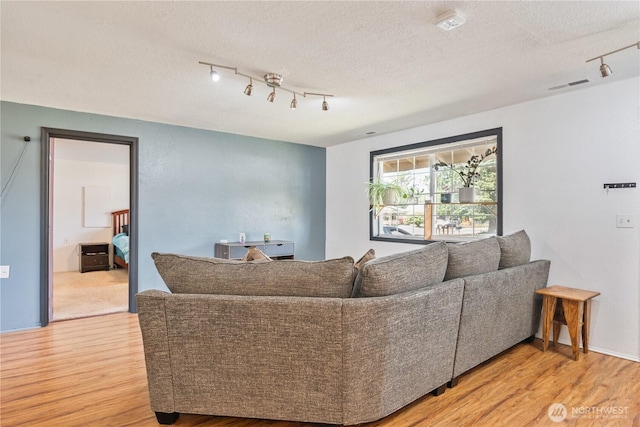 642 SW 5th Ave, Castle Rock, WA 98611 - living room featuring rail lighting, light wood-type flooring, and a textured ceiling
