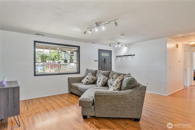 642 SW 5th Ave, Castle Rock, WA 98611 - living room with wood finished floors, a textured ceiling, and track lighting