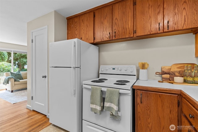 13523 23rd Pl NE, Seattle, WA 98125 - kitchen with white appliances, light countertops, brown cabinets, and light wood-style flooring