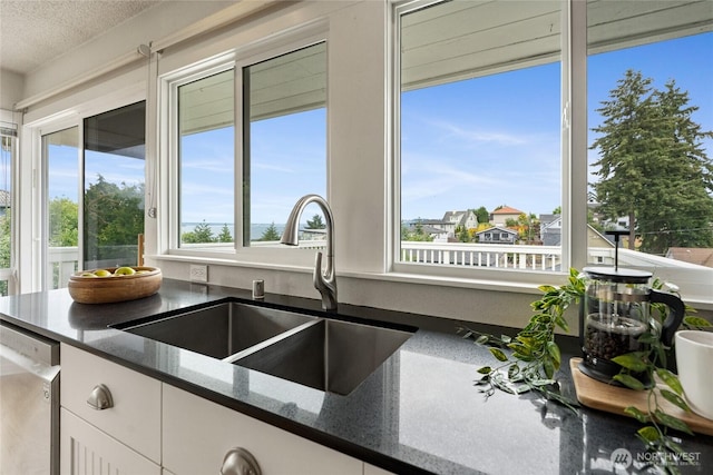 4815 N Huson St, Tacoma, WA 98407 - kitchen featuring dishwasher, plenty of natural light, dark stone countertops, white cabinetry, and a textured ceiling