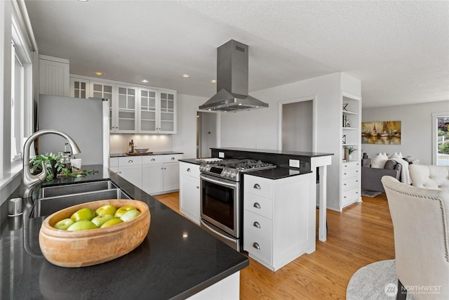 4815 N Huson St, Tacoma, WA 98407 - kitchen with island exhaust hood, gas range, dark countertops, freestanding refrigerator, and recessed lighting