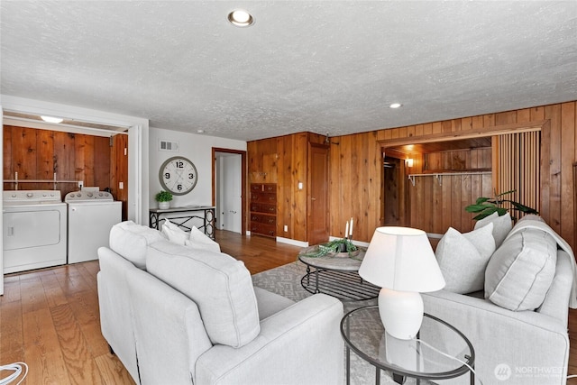 4815 N Huson St, Tacoma, WA 98407 - living room featuring washer and clothes dryer, wood finished floors, a textured ceiling, and wooden walls
