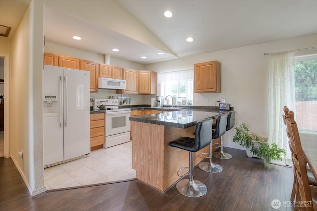 117 Bufflehead St SW, Ocean Shores, WA 98569 - kitchen with white appliances, vaulted ceiling, healthy amount of natural light, a breakfast bar area, and dark countertops