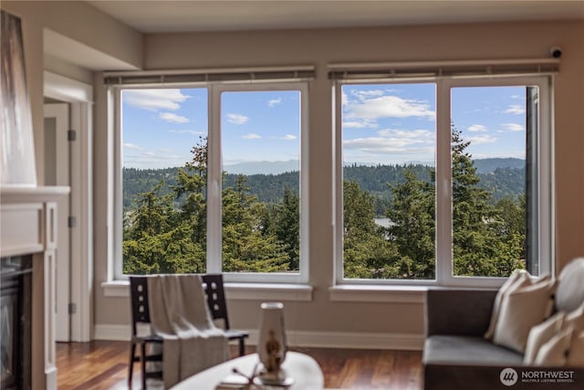 18707 SE Newport Way Unit 208, Issaquah, WA 98027 - living room featuring healthy amount of natural light, wood finished floors, and a view of trees