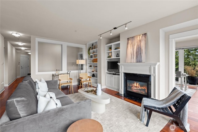 18707 SE Newport Way Unit 208, Issaquah, WA 98027 - living area with wood finished floors, a high end fireplace, built in shelves, and rail lighting