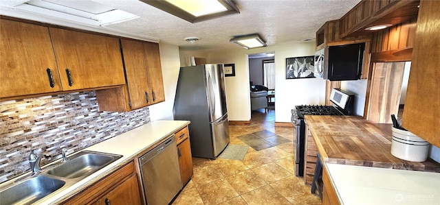 20354 Adrian Rd NE, Soap Lake, WA 98851 - kitchen with stainless steel appliances, backsplash, brown cabinetry, and a textured ceiling