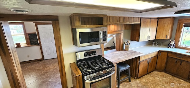 20354 Adrian Rd NE, Soap Lake, WA 98851 - kitchen with stainless steel appliances, a textured ceiling, light countertops, and light tile patterned floors
