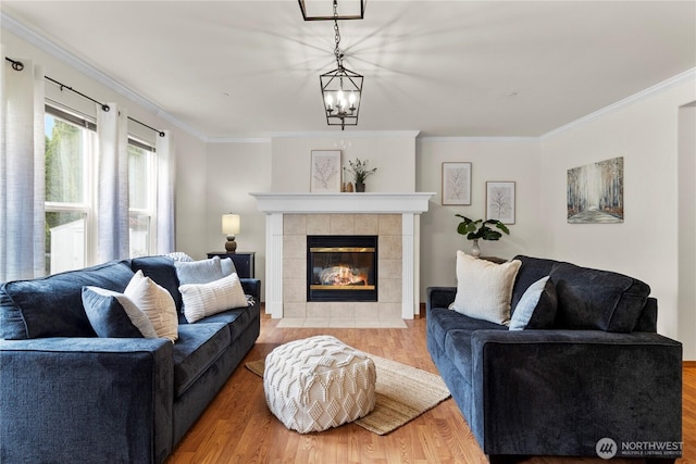 1662 Jensen Ave, Dupont, WA 98327 - living area featuring a chandelier, ornamental molding, a tile fireplace, and wood finished floors