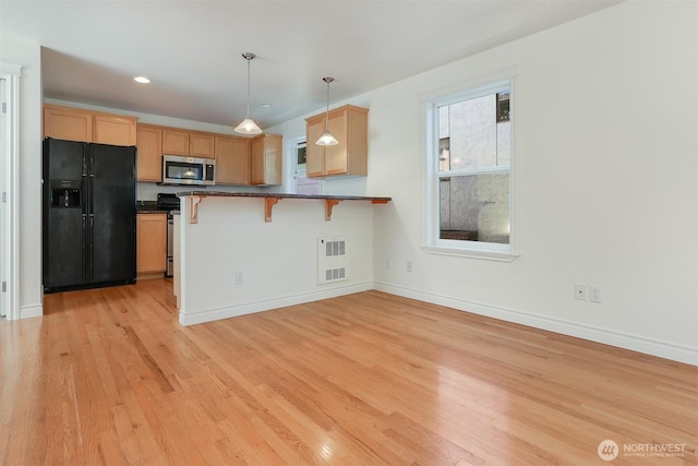 1426A NW 59th St, Seattle, WA 98107 - kitchen with stainless steel appliances, dark countertops, a breakfast bar area, light wood finished floors, and pendant lighting