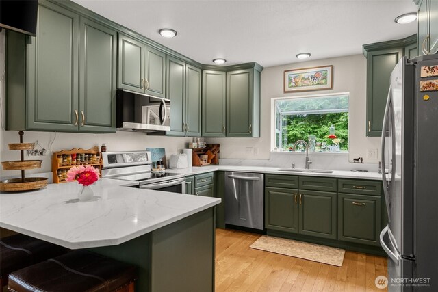 15526 SE 344th St, Auburn, WA 98092 - kitchen featuring green cabinets, appliances with stainless steel finishes, a peninsula, and light wood finished floors