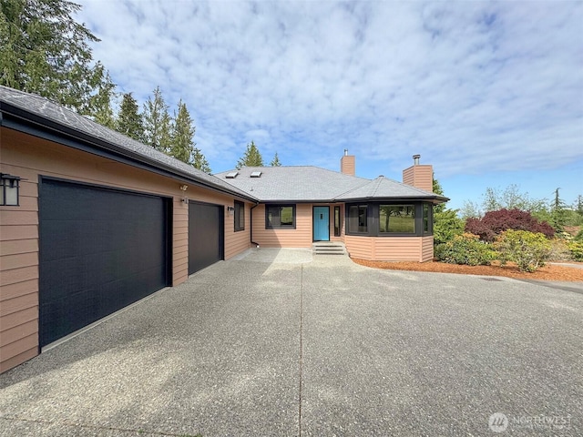 412 Doe Run Rd, Sequim, WA 98382 - view of front of property with a garage, driveway, a chimney, and roof with shingles