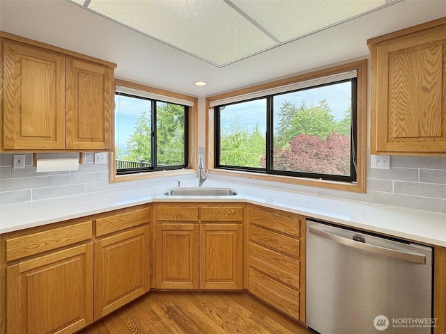 412 Doe Run Rd, Sequim, WA 98382 - kitchen featuring stainless steel dishwasher, light wood finished floors, light countertops, and backsplash