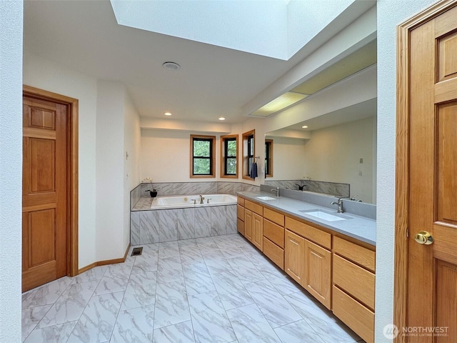 412 Doe Run Rd, Sequim, WA 98382 - bathroom featuring marble look tile flooring, a bath, double vanity, a skylight, and recessed lighting