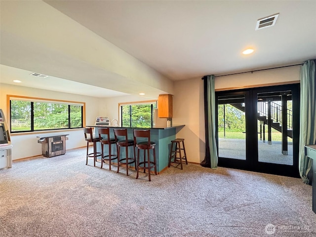 412 Doe Run Rd, Sequim, WA 98382 - kitchen with light carpet, a kitchen breakfast bar, recessed lighting, dark countertops, and french doors