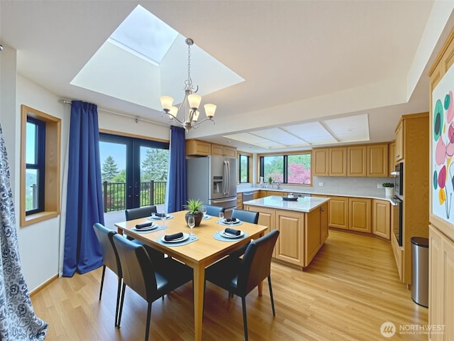 412 Doe Run Rd, Sequim, WA 98382 - dining room with light wood-style flooring, a chandelier, french doors, and a raised ceiling