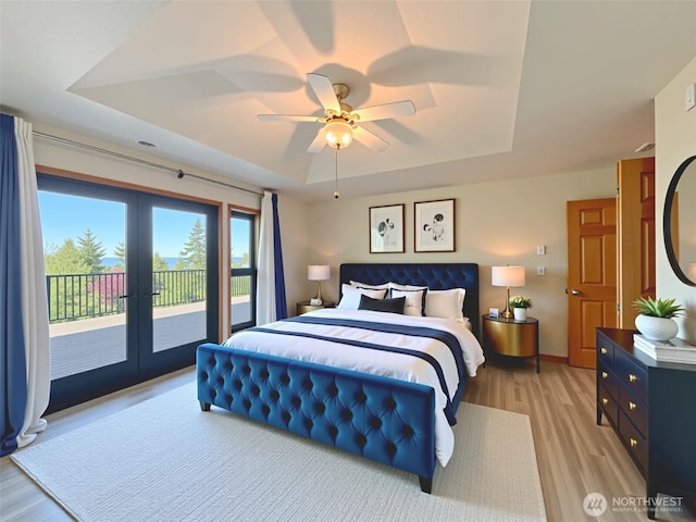 412 Doe Run Rd, Sequim, WA 98382 - bedroom featuring a tray ceiling, access to exterior, french doors, and light wood-style flooring
