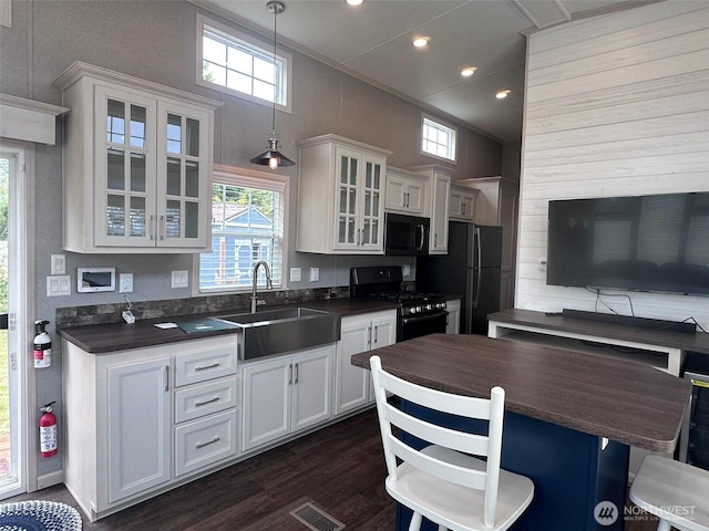 20 Golden Sands Pl, Sequim, WA 98382 - kitchen with black appliances, dark countertops, dark wood-style floors, a kitchen bar, and white cabinets
