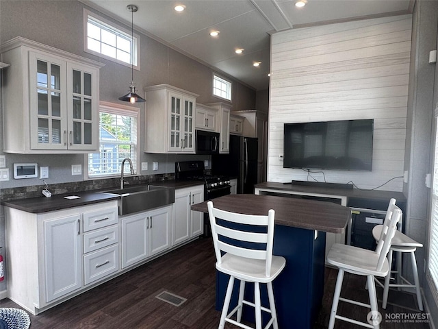 20 Golden Sands Pl, Sequim, WA 98382 - kitchen with dark countertops, black appliances, a center island, dark wood-type flooring, and white cabinets