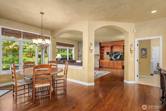 24817 NE 20th St, Sammamish, WA 98074 - dining space with wood finished floors, a chandelier, arched walkways, and recessed lighting
