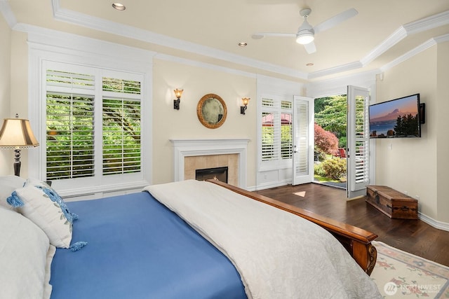 24817 NE 20th St, Sammamish, WA 98074 - bedroom featuring a raised ceiling, wood finished floors, ornamental molding, a tile fireplace, and a ceiling fan