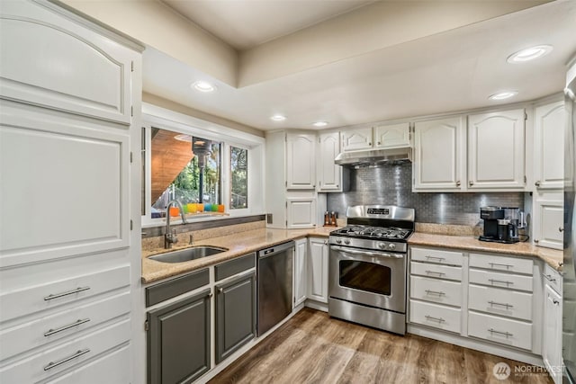 10218 NE 65th St, Kirkland, WA 98033 - kitchen with stainless steel appliances, under cabinet range hood, decorative backsplash, wood finished floors, and white cabinets